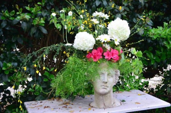 Flower arrangement in a vase shaped as a head - Isle of Wight Historic Home and Garden Tour, Virginia