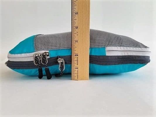 Zipped and compressed Packing Cube showing a ruler beside it to show how compact it gets with 5 T-shirts inside and both zippers closed.