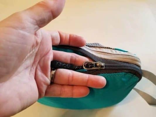 Photo of hand next to the zipper of a Packing Cube showing how to keep the zipper from snagging in the fabric.