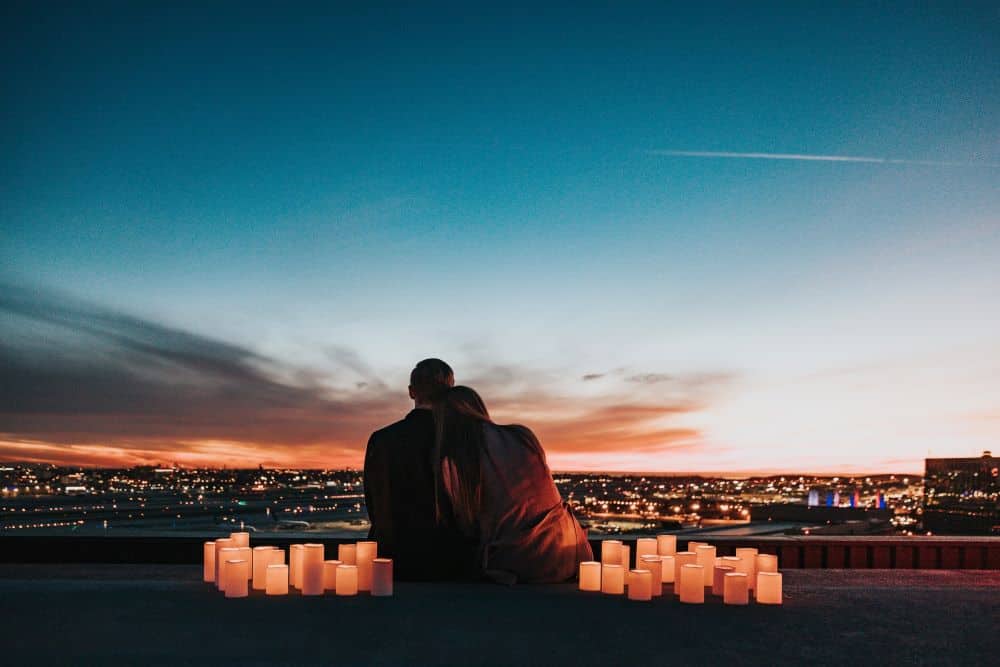 Couple overlooks the city at sunset