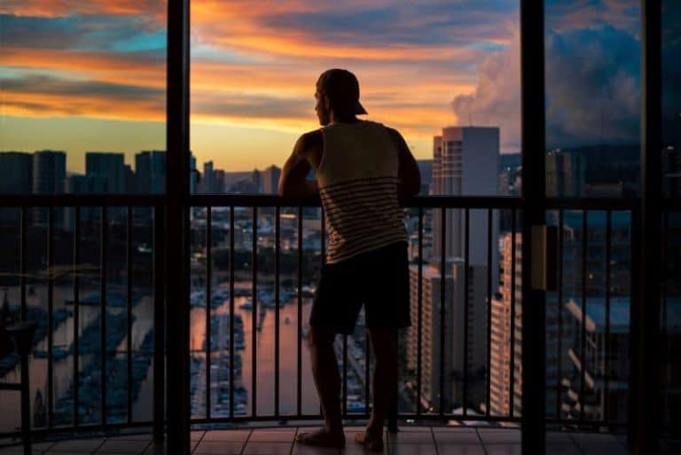 Man enjoying view of the city from balcony