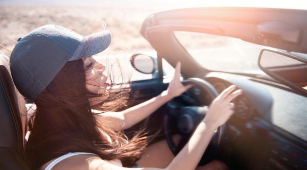 Woman singing road trip songs in car