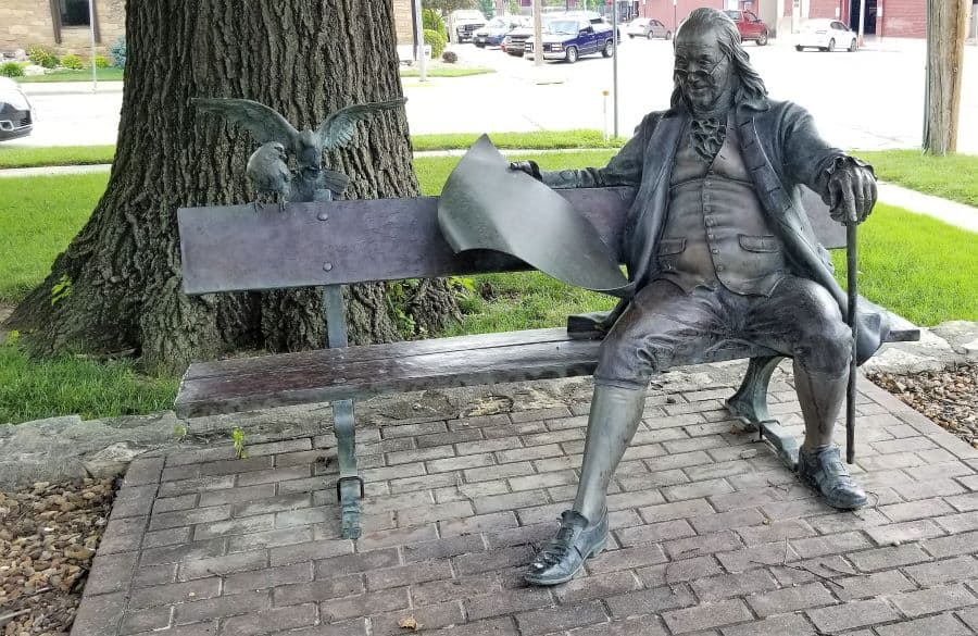 Sculpture of Benjamin Franklin sitting on a bench at Abilene Kansas Public Library
