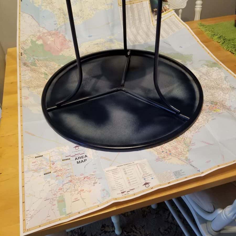 Round metal table upside down on top of a map