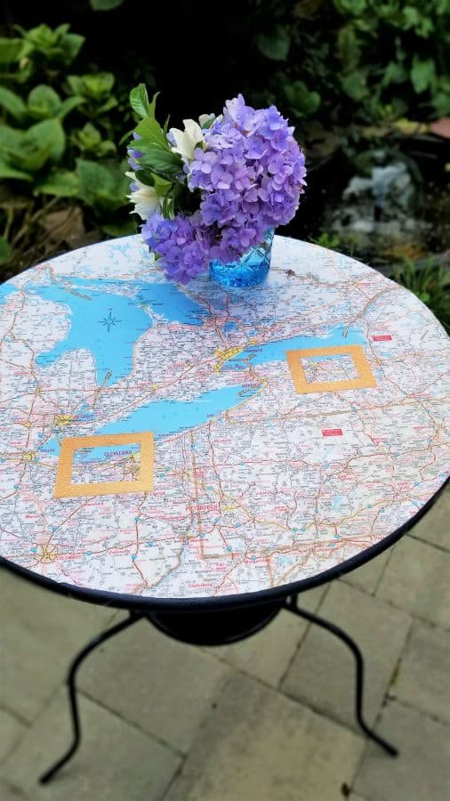 Round table with map and vase of flowers on tabletop