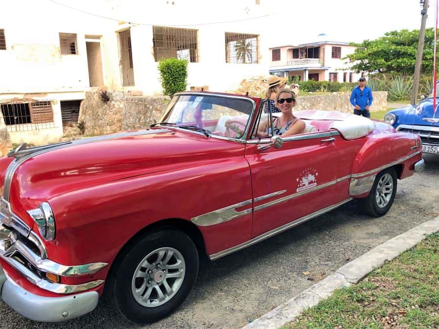 Vintage Red Convertible car with woman inside in Havana Cuba