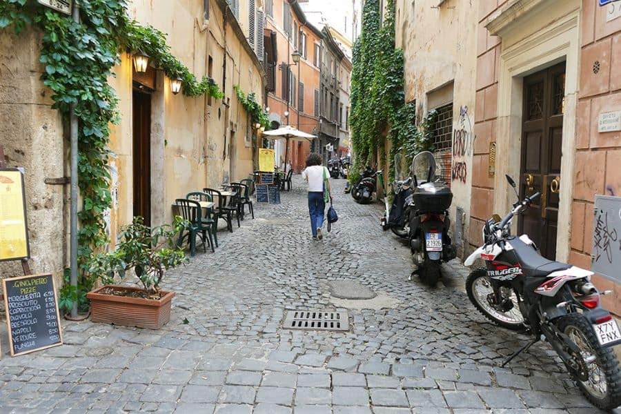 Man walking on cobblestone street in Italy