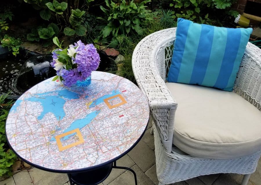Ikea table with map on top next to wicker chair