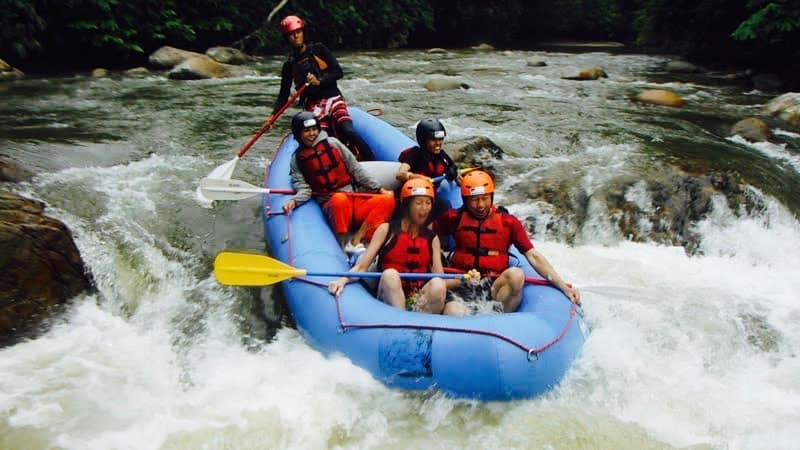 Whitewater rafters in a blue raft navigating rapids