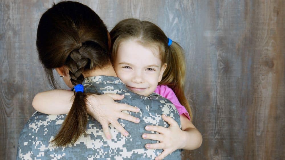 Woman in uniform hugging little girl