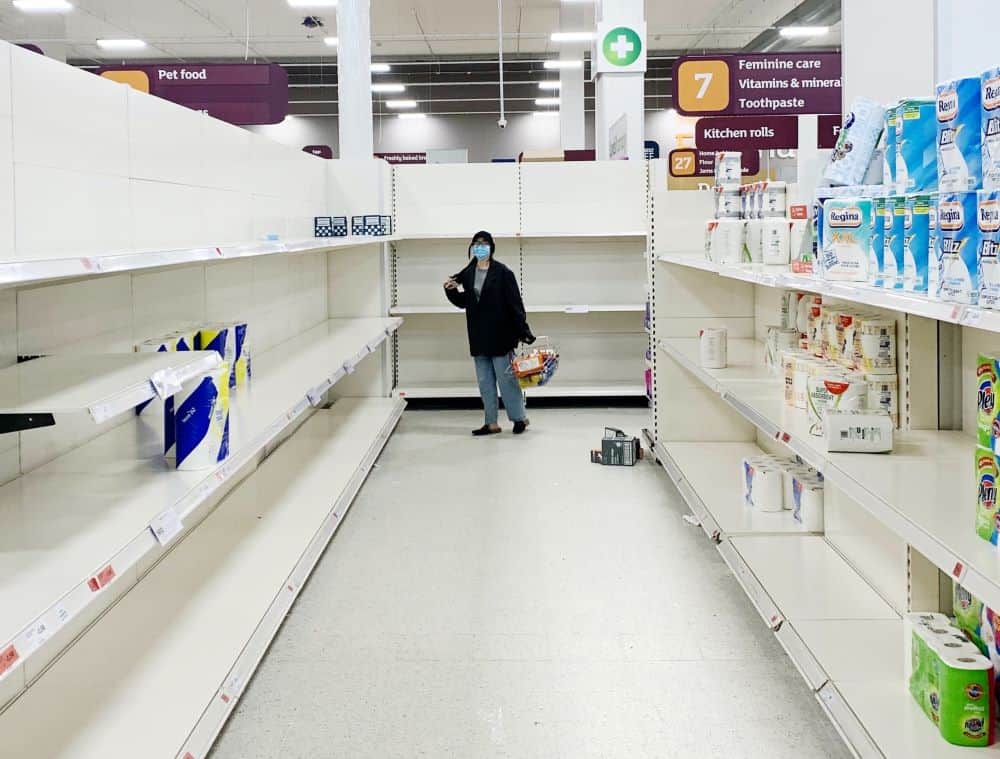 Shopper looking at Empty toilet paper aisle at store