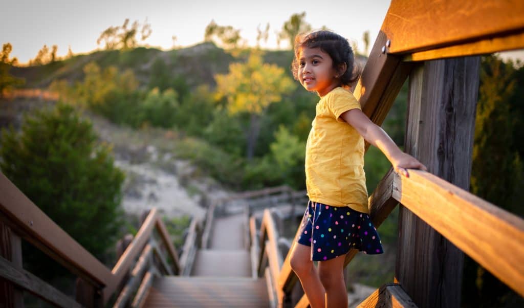 Young girl standing on boardwalk trail in park