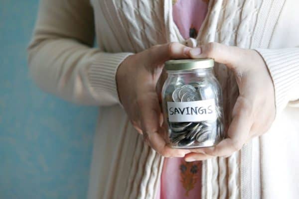 Woman saving money in jar