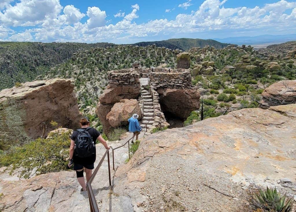man and woman hike up stone stairs in Arizona national park, Chiricahua