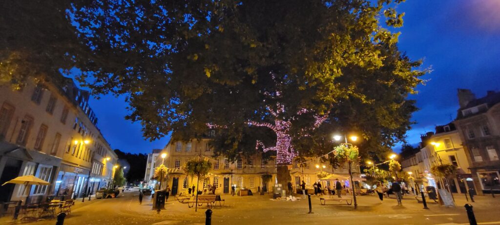 Massive tree decorated with white lights in a plaza in Bath England