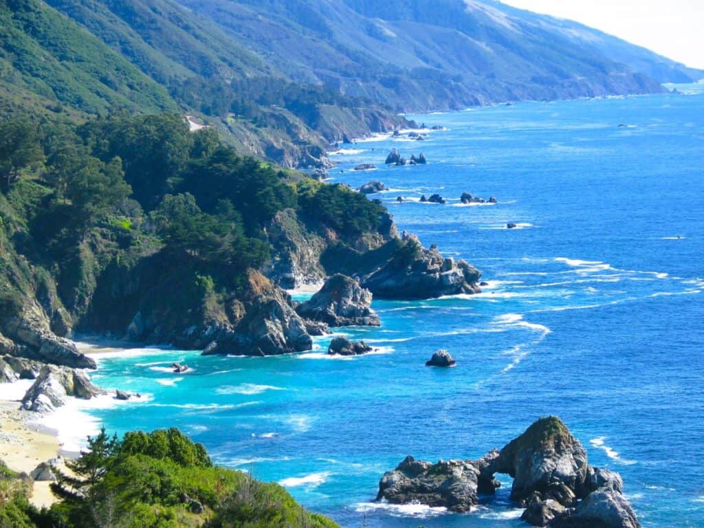 Rugged California coastline with green rocky shores and turquoise blue water