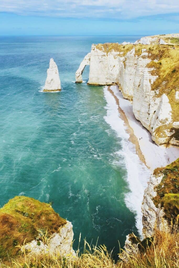 White cliffs and sandy beach with turquoise blue ocean water. Etretat, France, Normandy