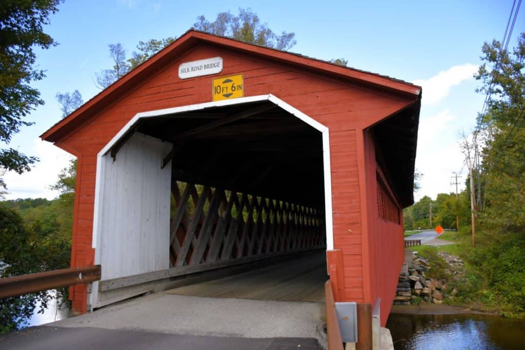 Things to do in Vermont in the fall - take a scenic drive to find some of the 100 historic covered bridges, like this red wooden Silk Road Bridge near Bennington, VT