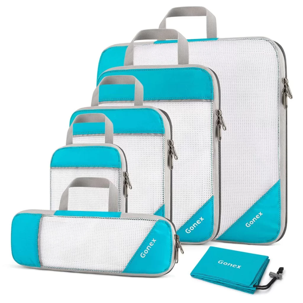 5-piece set of Gonex Compression Packing Cubes with white fabric handles and one side is mesh. All 5 are varying sizes to use for packing clothes and other items.