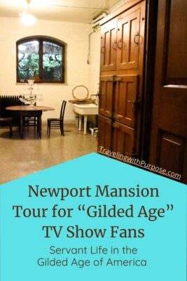 View into a basement room in the historic Elms mansion with a simple wooden table and two chairs. A vintage sink is on one wall and a large wooden cabinet is next to it. The window above shows that the floor is below ground level. Newport Gilded Age Mansions