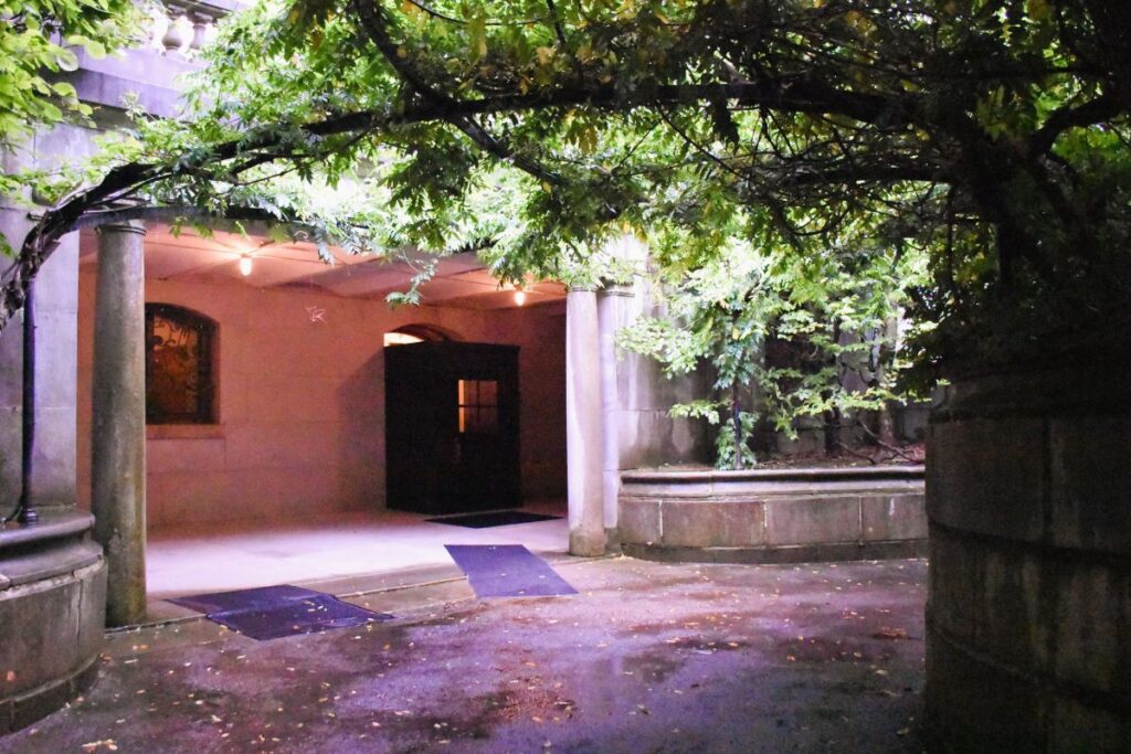 The servants' entrance at the Elms mansion is on the lower level, away from the main entrance so that visitors don't see the servants or deliveries happening. This vine-covered circular driveway allows for discreet coming and going away from the family and guests.