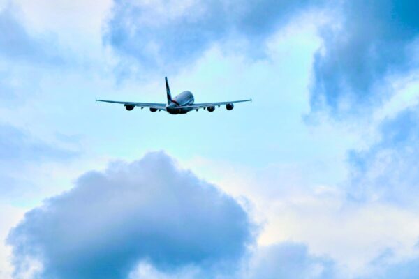 A commercial airplane flying through a gap in the clouds