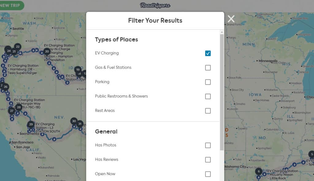 Screenshot of Roadtrippers app showing a USA map in the background and a list of the types of places you can choose to show on your trip route. List includes: EV Charging, Gas stations, parking, public restrooms and showers, and rest areas. 